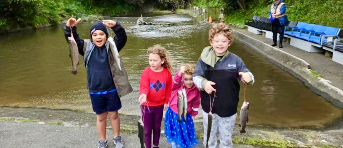Capital Trout Centre Fishing Day Four excited children eagerly showing off the trout they caught at the Capital Trout Centre