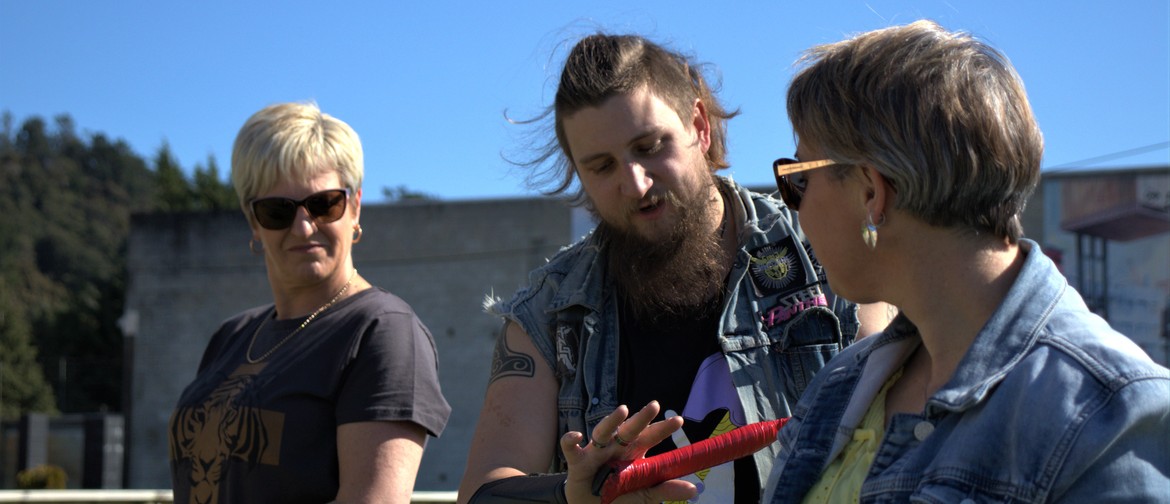 Axtion Packed Friday Fling Axe-pert training two women to throw an axe.
