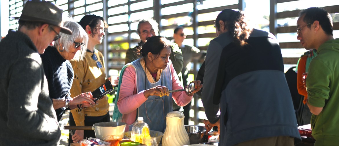 Inter-migrational Cooking Workshop woman cooking surrounded by other people