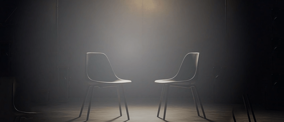 Whose Memory Lights The Dark Two chairs sit on a stage dimly lit by a single golden bulb