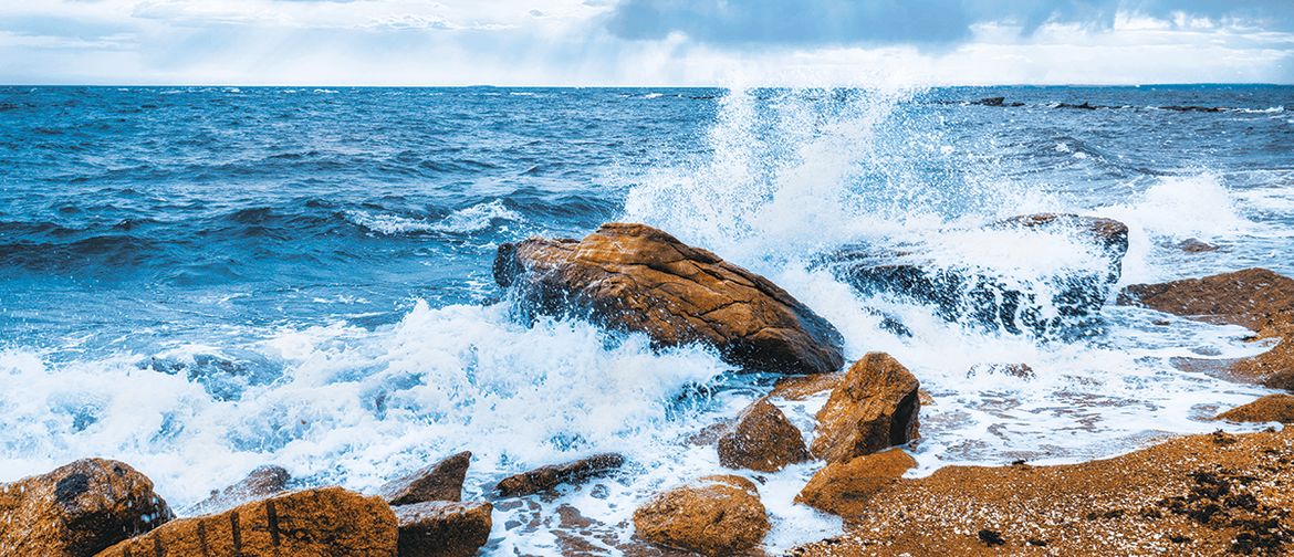 ocean waves crashing over rocks evoking cleansing and upliftment